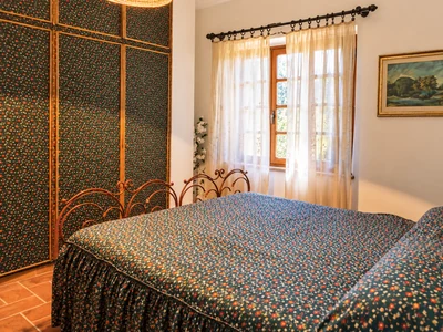 Camera da letto luminosa con tendaggi decorati e arredi in legno