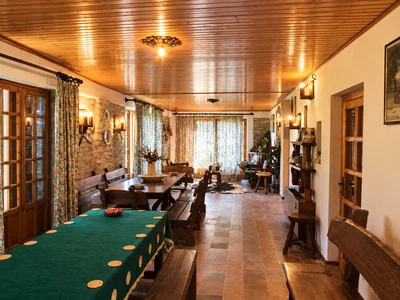 Sala da pranzo con tavolo in legno, sedie e soffitto rivestito in legno