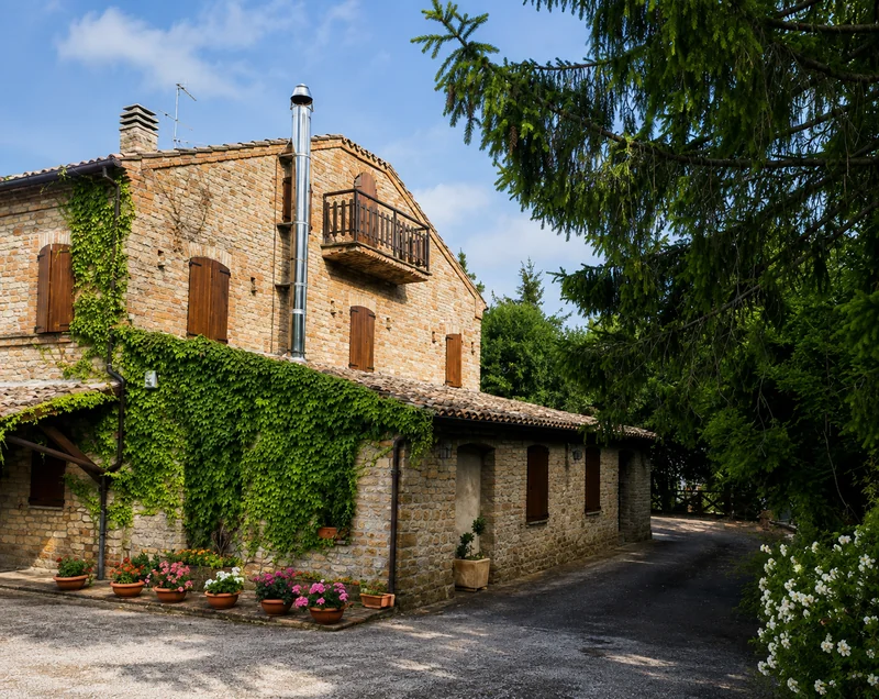 La facciata in pietra di Villa La Rupe, con balcone e porticato ricoperto di edera